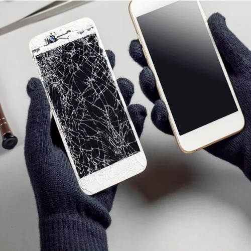 Técnico mostrando celular con pantalla rota y pantalla nueva